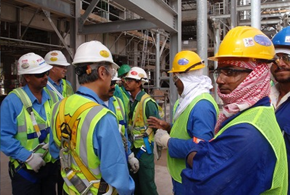 Frontline workers gathered in a group discussion, collaborating on safety and high‑performance practices.
